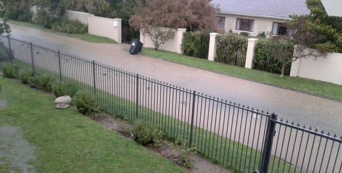 A flooded street overflows into a residential property